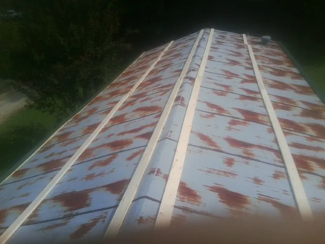 Rusted metal roof panels with new wood purlins before replacement — Storm Damage Roof Repair in Hernando by Roofing Brothers