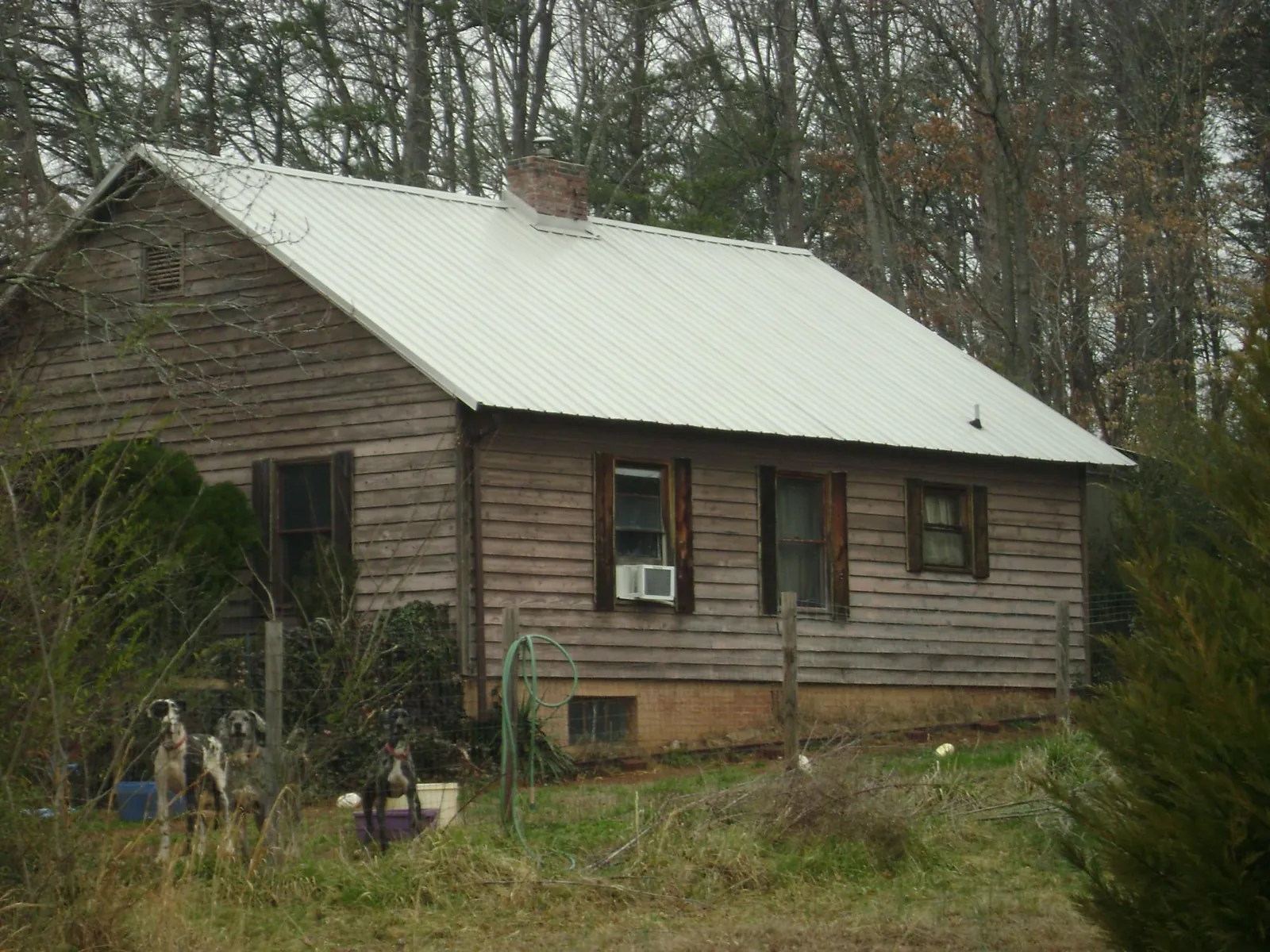 White metal roof on an old wood sided farmhouse, from a Metal Roof Installation job in Hernando
